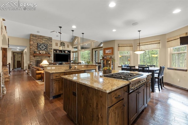 11720 Smokey Hill Grv, Colorado Springs, CO 80908 - kitchen featuring a large island, a stone fireplace, stainless steel appliances, dark wood-style flooring, and open floor plan