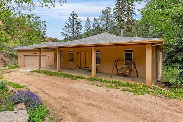 4775 Neeper Valley Rd, Manitou Springs, CO 80829 - view of front facade featuring a garage, stucco siding, and driveway