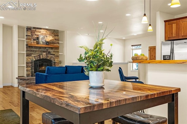 4775 Neeper Valley Rd, Manitou Springs, CO 80829 - dining space with light wood-style flooring, recessed lighting, a fireplace, built in features, and baseboards