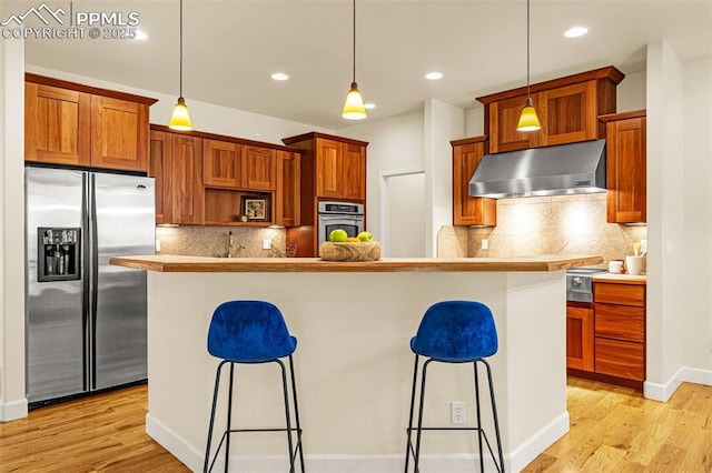 4775 Neeper Valley Rd, Manitou Springs, CO 80829 - kitchen with stainless steel appliances, range hood, a kitchen bar, light wood finished floors, and recessed lighting