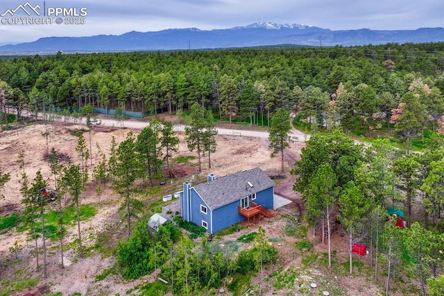 12475 Hereford Way, Colorado Springs, CO 80908 - aerial view of property and surrounding area featuring a heavily wooded area and a mountain backdrop