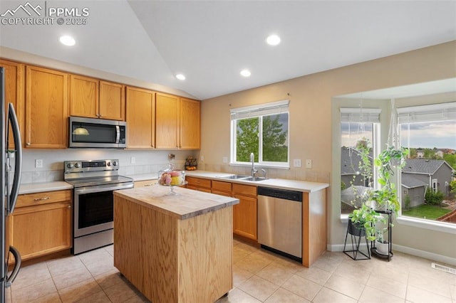 6755 Akerman Dr, Colorado Springs, CO 80923 - kitchen with stainless steel appliances, a sink, butcher block counters, lofted ceiling, and a kitchen island