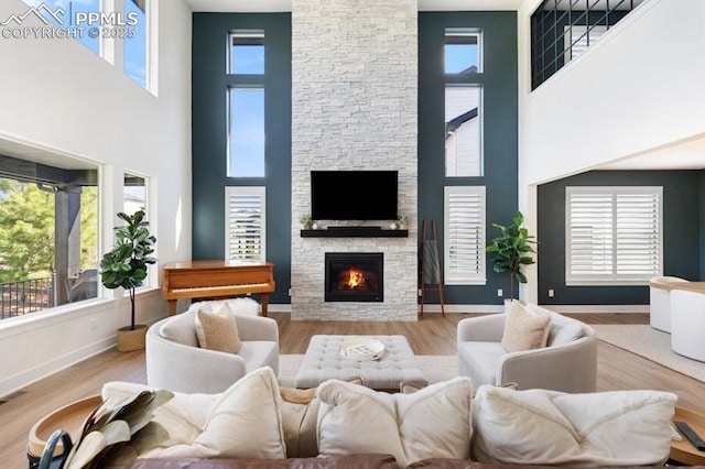 455 Rogers Way, Castle Rock, CO 80104 - living room featuring a towering ceiling, plenty of natural light, a fireplace, and wood finished floors