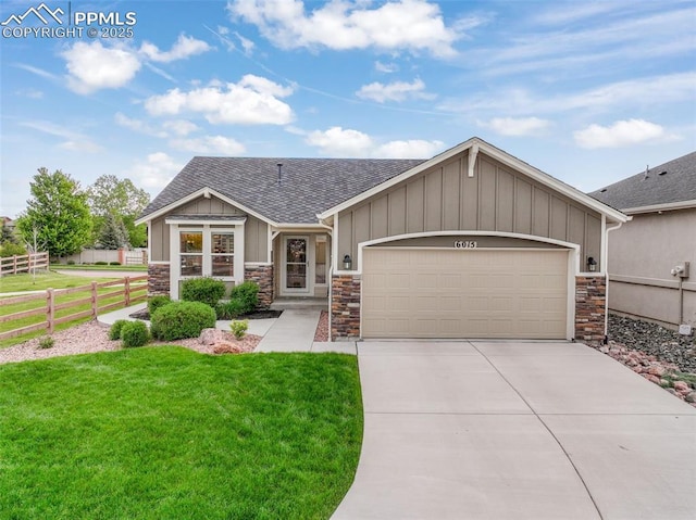 6015 Trappers Tale Ct, Colorado Springs, CO 80923 - view of front of house with stone siding, a shingled roof, driveway, and a garage