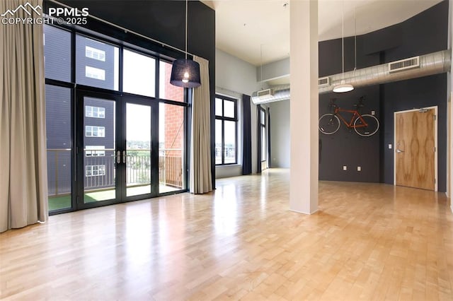 3100 Huron St Unit 4N, Denver, CO 80202 - spare room featuring a towering ceiling, wood finished floors, and french doors
