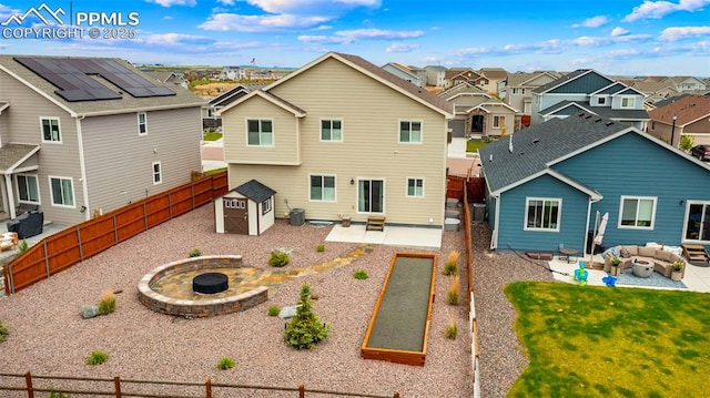 10552 Summer Ridge Dr, Peyton, CO 80831 - rear view of property featuring a residential view, a patio, an outdoor living space with a fire pit, and a fenced backyard