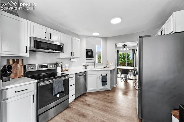 2280 Lisa Dr, Colorado Springs, CO 80915 - kitchen with stainless steel appliances, a sink, white cabinets, light countertops, and a ceiling fan