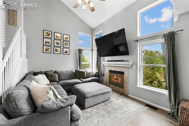 2280 Lisa Dr, Colorado Springs, CO 80915 - living area featuring high vaulted ceiling, ceiling fan, wood finished floors, a tile fireplace, and baseboards