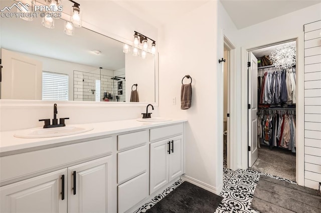 2513 Cinnabar Rd, Colorado Springs, CO 80921 - bathroom with double vanity, a tile shower, a spacious closet, and baseboards