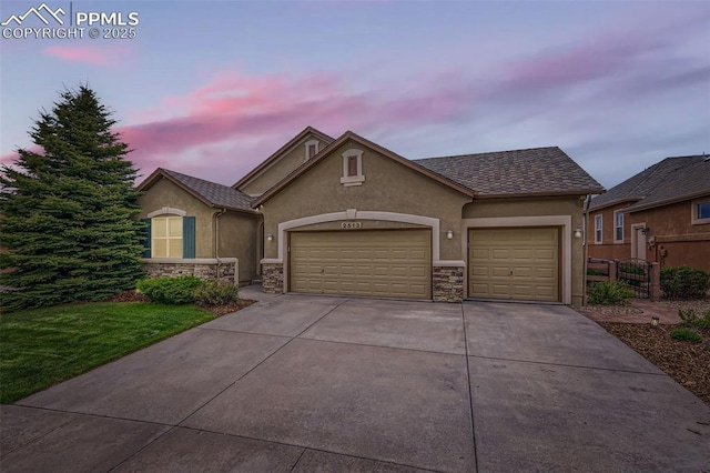 2513 Cinnabar Rd, Colorado Springs, CO 80921 - traditional-style house with stucco siding, driveway, stone siding, and an attached garage