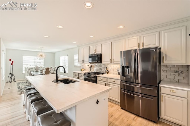 2513 Cinnabar Rd, Colorado Springs, CO 80921 - kitchen featuring stainless steel fridge with ice dispenser, a sink, gas stove, a breakfast bar area, and light countertops