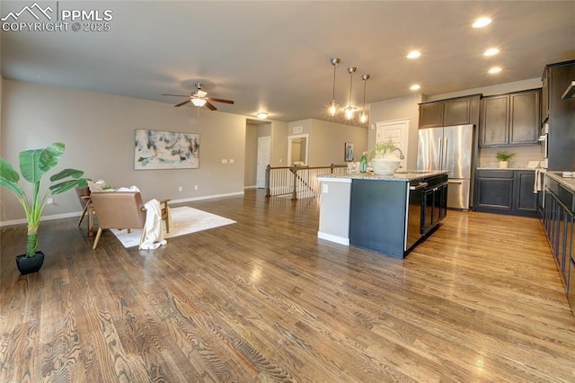 4228 Notch Trl, Colorado Springs, CO 80924 - kitchen featuring freestanding refrigerator, ceiling fan, an island with sink, light stone counters, and recessed lighting