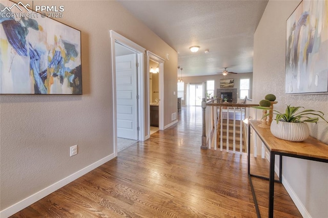4228 Notch Trl, Colorado Springs, CO 80924 - hallway featuring a textured wall, baseboards, and wood finished floors