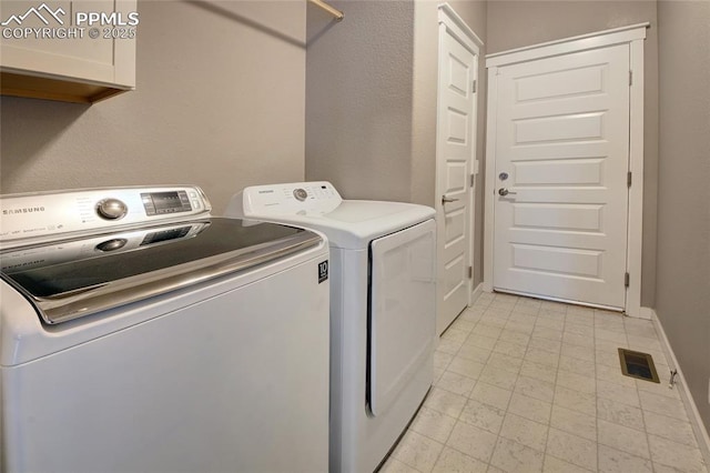 4228 Notch Trl, Colorado Springs, CO 80924 - laundry area featuring washing machine and dryer, cabinet space, baseboards, and light tile patterned floors