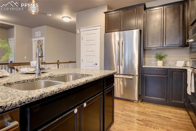 4228 Notch Trl, Colorado Springs, CO 80924 - kitchen featuring freestanding refrigerator, a sink, light stone countertops, and dark brown cabinetry