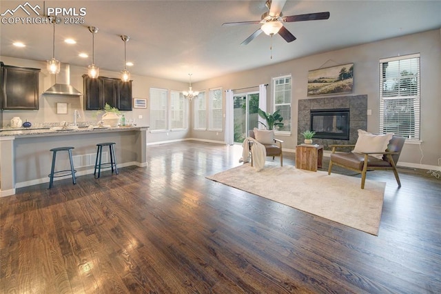 4228 Notch Trl, Colorado Springs, CO 80924 - living area with baseboards, a chandelier, ceiling fan, dark wood-style flooring, and a fireplace