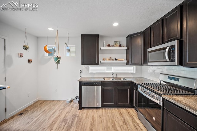 5840 Thurless Ln, Colorado Springs, CO 80927 - kitchen with appliances with stainless steel finishes, light wood-type flooring, a sink, tasteful backsplash, and baseboards