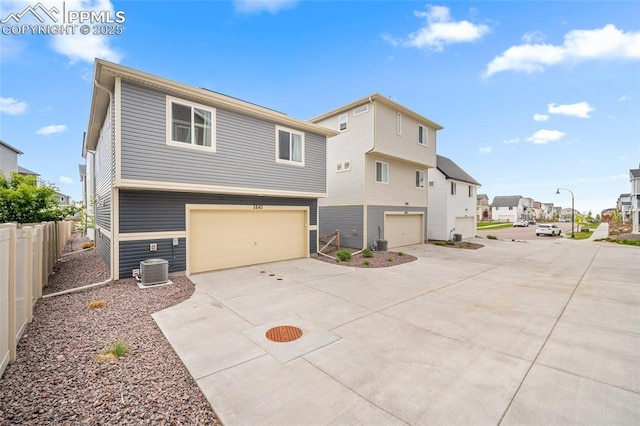 5840 Thurless Ln, Colorado Springs, CO 80927 - back of property featuring an attached garage, concrete driveway, central air condition unit, and a residential view