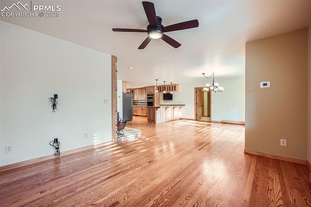 14820 Spiritwood Loop, Elbert, CO 80106 - unfurnished living room with a ceiling fan, a chandelier, and light wood-style floors