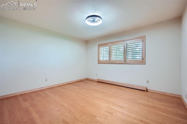 14820 Spiritwood Loop, Elbert, CO 80106 - empty room featuring a baseboard heating unit, wood finished floors, and a textured ceiling