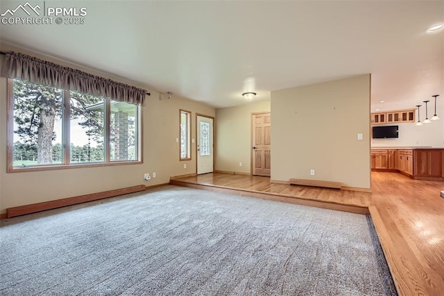 14820 Spiritwood Loop, Elbert, CO 80106 - unfurnished living room featuring light carpet, light wood-style floors, and recessed lighting