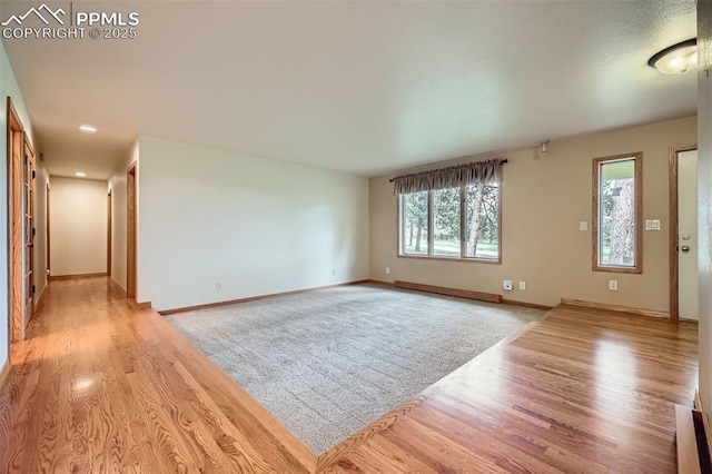 14820 Spiritwood Loop, Elbert, CO 80106 - unfurnished living room with light wood finished floors and baseboard heating