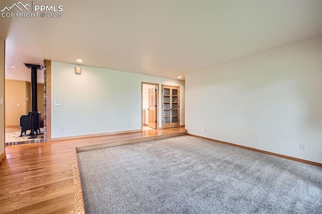14820 Spiritwood Loop, Elbert, CO 80106 - unfurnished room with a wood stove, recessed lighting, and wood finished floors