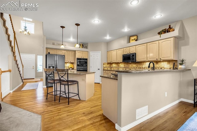 12265 Jones Park Ct, Colorado Springs, CO 80921 - kitchen with black appliances, light wood finished floors, dark stone counters, light brown cabinetry, and recessed lighting