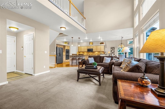 12265 Jones Park Ct, Colorado Springs, CO 80921 - living area featuring light colored carpet, a towering ceiling, and baseboards