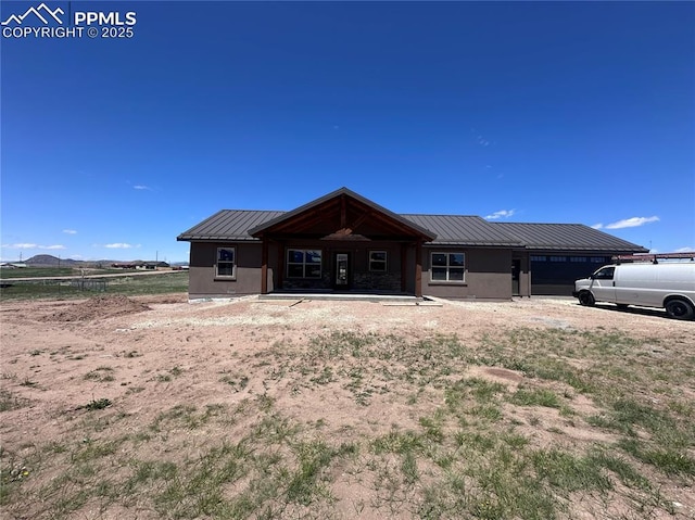 55 Kryptonite Ct, Westcliffe, CO 81252 - back of house with metal roof, an attached garage, and stucco siding