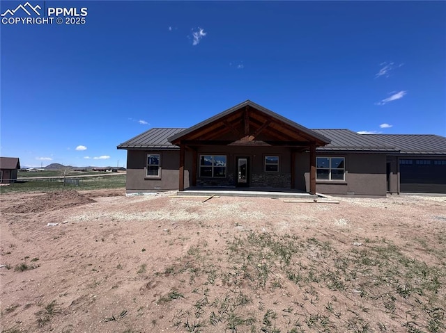 55 Kryptonite Ct, Westcliffe, CO 81252 - back of property with a standing seam roof, metal roof, stucco siding, and a garage