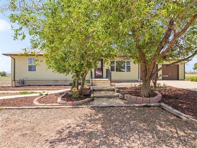 1159 N Linda Ln, Pueblo West, CO 81007 - view of property hidden behind natural elements featuring concrete driveway and a garage
