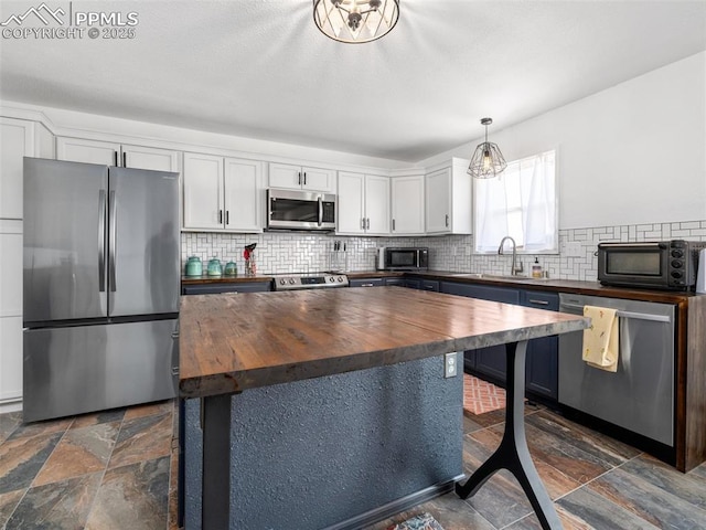 1159 N Linda Ln, Pueblo West, CO 81007 - kitchen featuring stainless steel appliances, wooden counters, stone tile flooring, and a sink