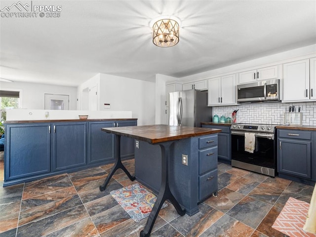 1159 N Linda Ln, Pueblo West, CO 81007 - kitchen with stainless steel appliances, butcher block countertops, blue cabinets, and a center island
