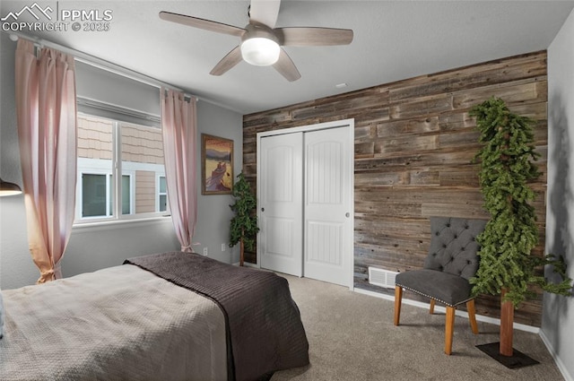 8795 Canary Cir, Colorado Springs, CO 80908 - carpeted bedroom featuring wooden walls, an accent wall, a closet, a ceiling fan, and baseboards