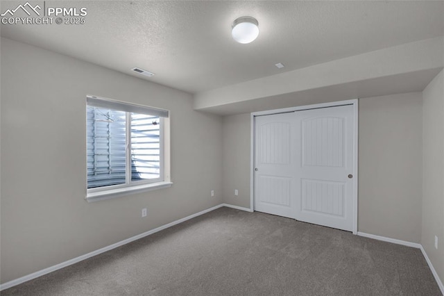 8795 Canary Cir, Colorado Springs, CO 80908 - unfurnished bedroom with a textured ceiling, carpet floors, baseboards, and a closet