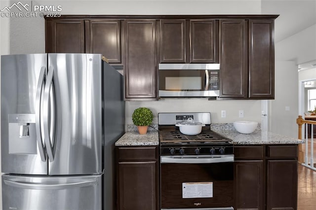 8795 Canary Cir, Colorado Springs, CO 80908 - kitchen featuring stainless steel appliances, dark brown cabinets, and light stone countertops