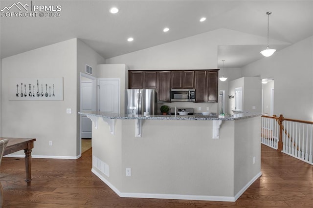 8795 Canary Cir, Colorado Springs, CO 80908 - kitchen featuring stainless steel appliances, dark brown cabinets, a breakfast bar, dark wood-type flooring, and recessed lighting