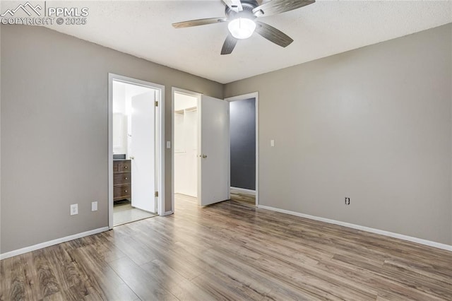 4708 Sprucewood Dr, Colorado Springs, CO 80918 - unfurnished bedroom featuring wood finished floors, baseboards, a spacious closet, and ensuite bathroom