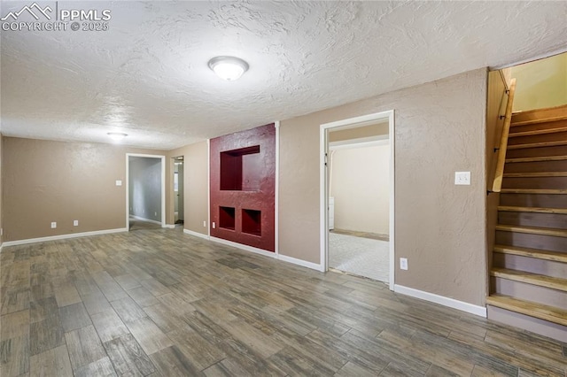 4708 Sprucewood Dr, Colorado Springs, CO 80918 - unfurnished living room with a textured ceiling, wood finished floors, stairs, a textured wall, and baseboards