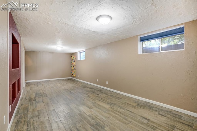 4708 Sprucewood Dr, Colorado Springs, CO 80918 - below grade area featuring a textured ceiling, wood finished floors, baseboards, and a textured wall