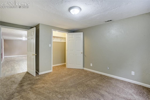 4708 Sprucewood Dr, Colorado Springs, CO 80918 - unfurnished bedroom featuring carpet, a textured ceiling, baseboards, a walk in closet, and a closet