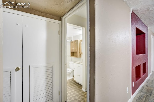 4708 Sprucewood Dr, Colorado Springs, CO 80918 - hallway featuring tile patterned floors, baseboards, and a textured wall