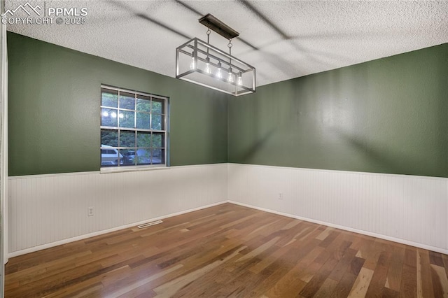 4708 Sprucewood Dr, Colorado Springs, CO 80918 - unfurnished room featuring wainscoting, wood finished floors, and a textured ceiling