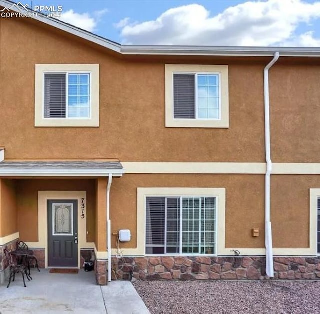 7315 Forest Meadows Ave, Colorado Springs, CO 80908 - view of exterior entry featuring stone siding, stucco siding, and a patio