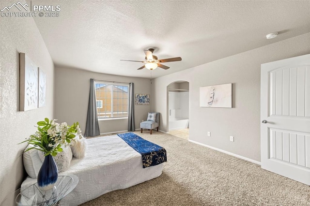 7315 Forest Meadows Ave, Colorado Springs, CO 80908 - carpeted bedroom with arched walkways, a textured ceiling, baseboards, ensuite bath, and a ceiling fan