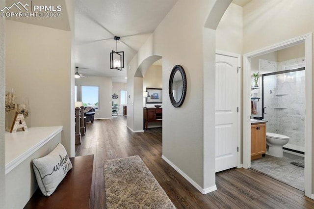 15506 Short Line Ct, Monument, CO 80132 - hallway with arched walkways, dark wood finished floors, and baseboards