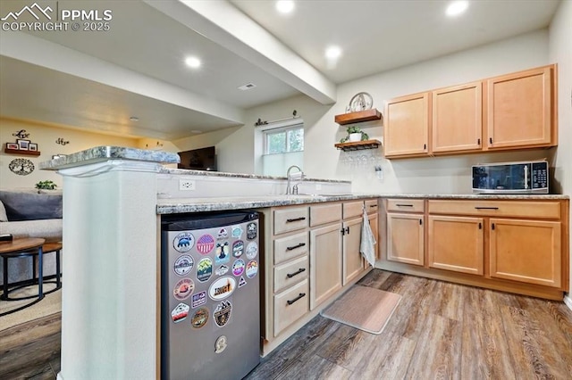 15506 Short Line Ct, Monument, CO 80132 - kitchen with stainless steel microwave, refrigerator, wood finished floors, open shelves, and light stone countertops