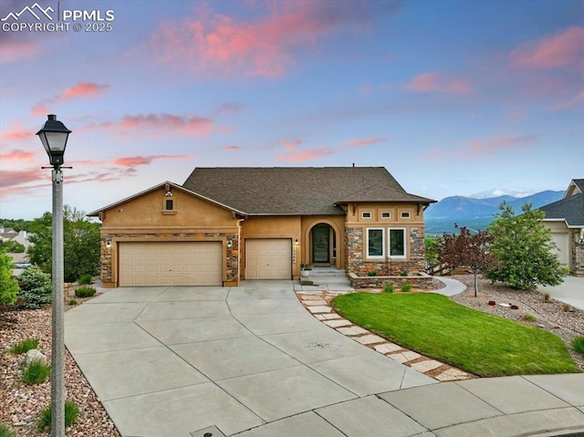 15506 Short Line Ct, Monument, CO 80132 - view of front facade with stucco siding, concrete driveway, stone siding, a garage, and a front yard