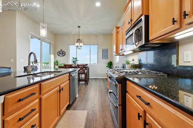 15506 Short Line Ct, Monument, CO 80132 - kitchen with appliances with stainless steel finishes, a sink, dark wood-style floors, hanging light fixtures, and recessed lighting